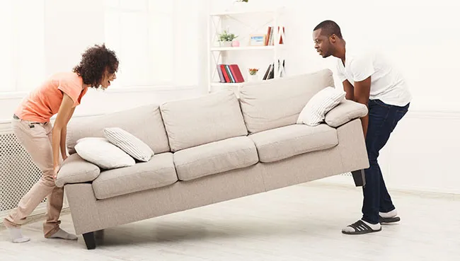 Couple moving sofa | Key Carpet Corporation