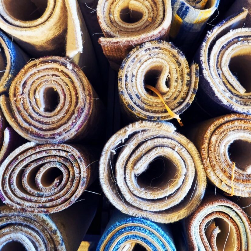 Variety of colorful carpets rolled up for display in a warehouse | Key Carpet Corporation